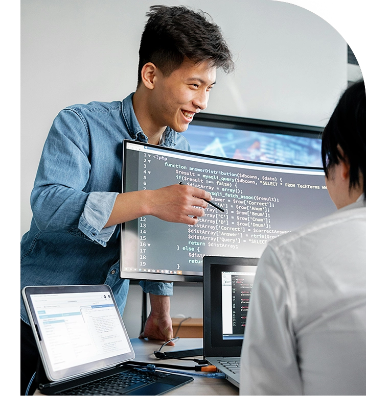 Man pointing at code on screen, explaining.