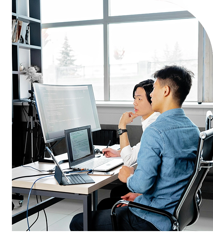 Two men working on computers in an office.